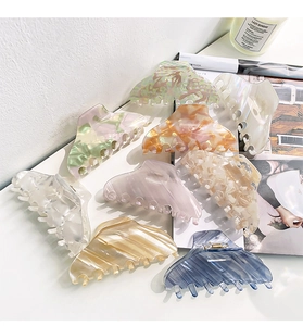 Detail view of colorful acetate hair claws with marble and shell patterns in a home setting