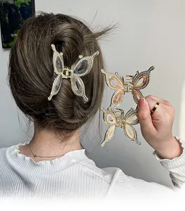 Detail of metal butterfly hair claw with sparkling rhinestones and pink resin finish