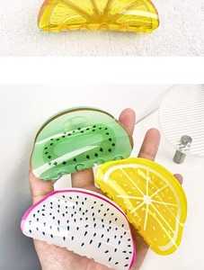 Close-up showing colorful acrylic fruit claw clips in lemon, kiwi, and dragon fruit shapes