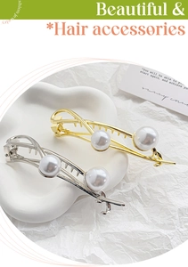 Close-up of gold and silver barrette clips with white pearls and crisscross metal design