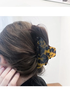 Macro detail of large tortoiseshell pattern hair claw clip for elegant updo hairstyling