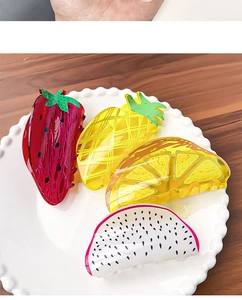 Set of four colorful acrylic fruit hair claws including strawberry, lemon, and pineapple