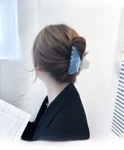 Blue marble texture claw clip for hair styling shown on a model's elegant updo