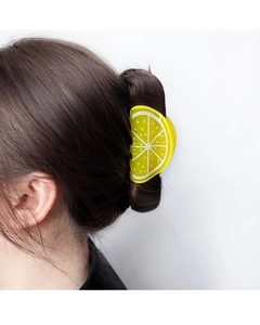 Detailed view of yellow acrylic lemon hair claw clip styled on a brunette model's hair