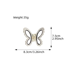Elegant gold butterfly hair claw with white rhinestones and black enamel detail