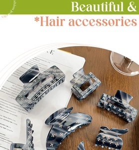 Detailed view of marble pattern hair claws with rhinestone accents on a wooden background
