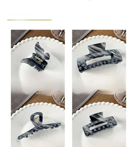 Detailed views of four blue acetate hair claws with sparkling rhinestones and marble patterns