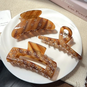 Three-piece tortoiseshell hair claw clips set with sparkling rhinestone floral patterns
