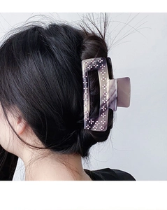 Détail de la pince à cheveux en acétate violet marbré avec motifs floraux en strass