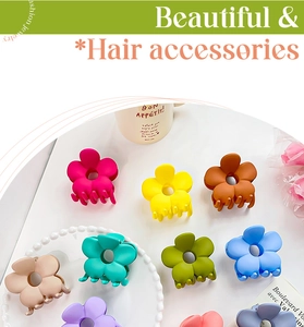 Gros plan de pinces à cheveux en forme de fleur mate aux couleurs pastel sur un bureau blanc