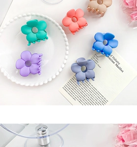 Gros plan de pinces à cheveux fleur mat pastel sur une assiette décorative blanche