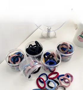 Detail of high-elasticity ribbed hair ties in assorted colors with a storage jar