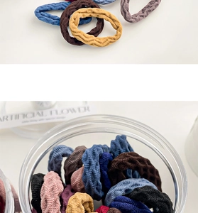 Detailed macro view of Morandi-colored high-elasticity hair ties with wave texture in a jar