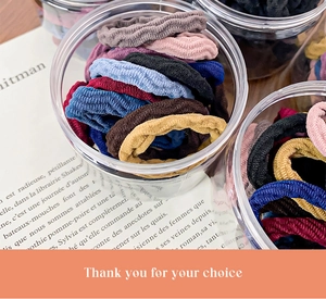 Cylindrical jar with colorful high-elasticity seamless hair ties on vintage book