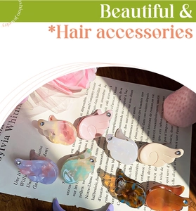 Detailed view of angel wing hair clips in acetate with rhinestone accents on a magazine