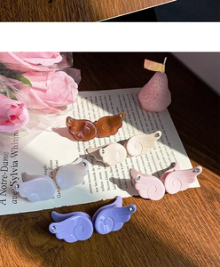 Detail view of acetate angel wing hair clips with rhinestone accents in soft lighting
