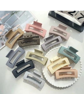 Detail showing 10 Morandi colored matte rectangular hair claws on a white tray