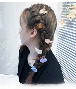 Detail of colorful angel wing hair clips with rhinestones worn on a braided hairstyle