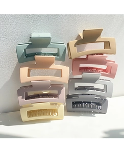 Matte rectangle claw clips in pastel colors stacked against a white wall with natural light