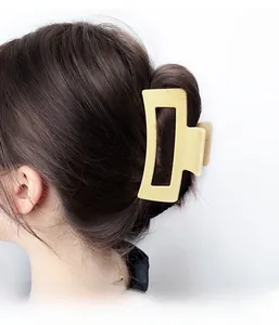 Matte pale yellow rectangular hair claw clip shown on brunette hair with sleek finish