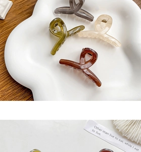 Detalle de cuatro pinzas para el cabello de resina translúcida con un elegante diseño de cinta