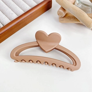 Détail d'une grande pince à cheveux coeur évidée de 13 cm en café clair mat