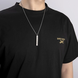 Close-up of a silver vertical bar pendant necklace with pavé-set zircons on a model