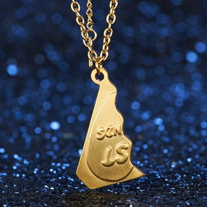 Macro detail of gold irregular puzzle pendant with SON IS engraving on a link chain