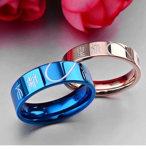 Detailed view of couple rings in blue and rose gold with matching heart engraving
