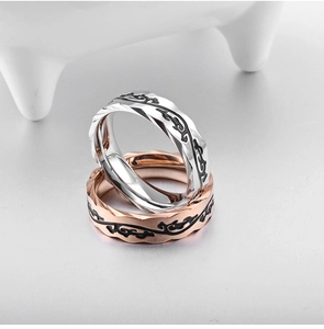 Detailed view of vine patterns on mirrored geometric rings in silver and rose gold finish