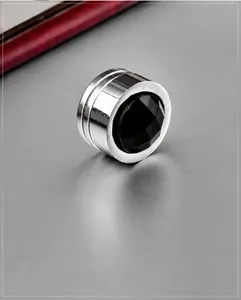 Macro detail of magnetic steel earring with faceted black zircon and silver polished finish