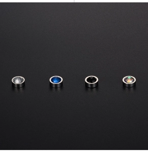 Close-up of four-piece magnetic stud earring set with faceted crystals in various colors