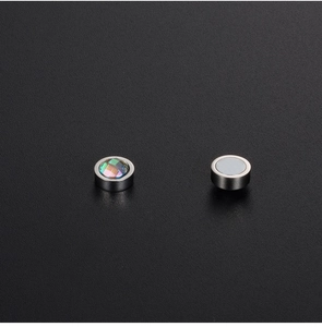 Macro shot of magnetic earrings with rainbow gemstone inlay and polished steel base