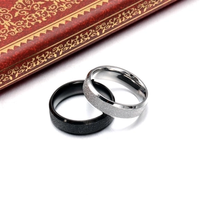 Close-up of black and silver titanium rings featuring a frosted matte sand finish