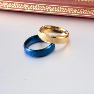 Detail of titanium steel rings with matte frosted finish in gold and blue colors
