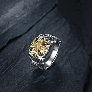 Macro shot of gothic cross ring featuring vintage gold texture and silver vine engravings