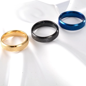 Detailed macro view of 6mm matte frosted rings in gold, black, and blue finishes