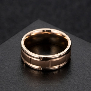 Détail d'une bague en titane or rose avec rainures verticales et finition métal brossé