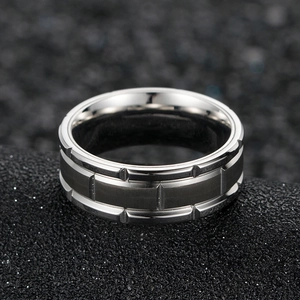 Détail macro d'une bague en titane pour homme avec métal brossé et rainures géométriques