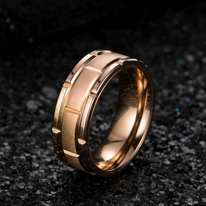 Vue macro d'une bague pour homme en acier inoxydable brossé or rose avec rainures modernes