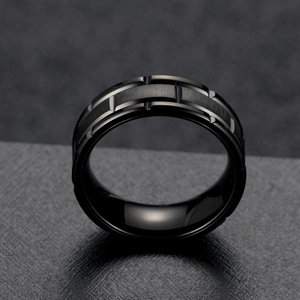 Bague pour homme en acier inoxydable brossé noir avec bords rainurés sur fond sombre