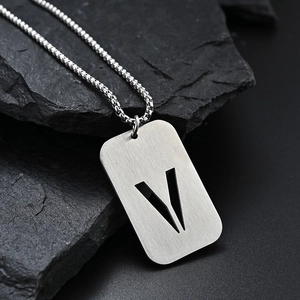 Brushed stainless steel dog tag necklace with cutout letter V on black rock
