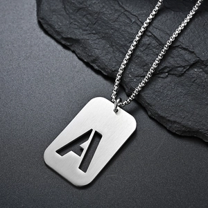 Macro shot of silver letter A cutout pendant on a metal ball chain for men
