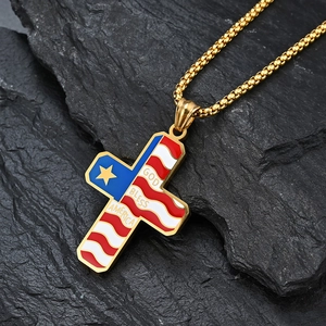 Macro shot of gold stainless steel cross necklace with God Bless America engraving