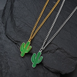 Collana con ciondolo a forma di cactus in smalto verde in oro e argento su sfondo di roccia
