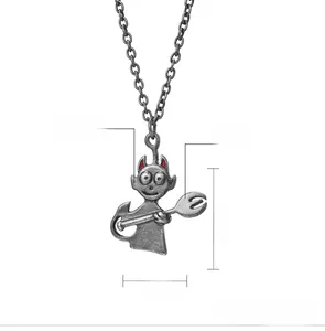 Detail of silver demon pendant with red horns and trident in a retro hip-hop style