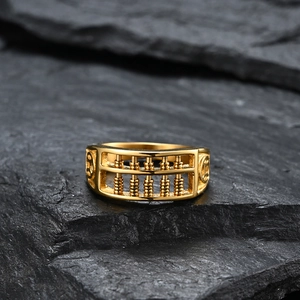 Golden titanium steel abacus ring with ancient coin motifs on a black stone background