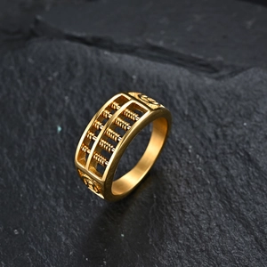 Macro shot of gold-plated abacus ring featuring movable beads and ancient coin symbols