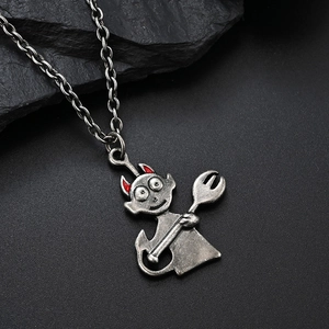 Macro detail of retro devil pendant with red horns on vintage silver chain necklace