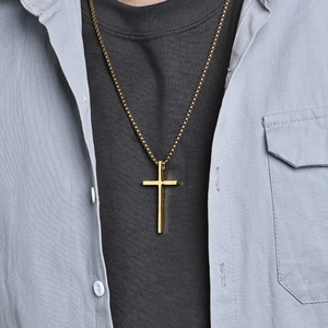 Klassische goldene Edelstahl-Kreuz-Halskette getragen auf einem schwarzen T-Shirt